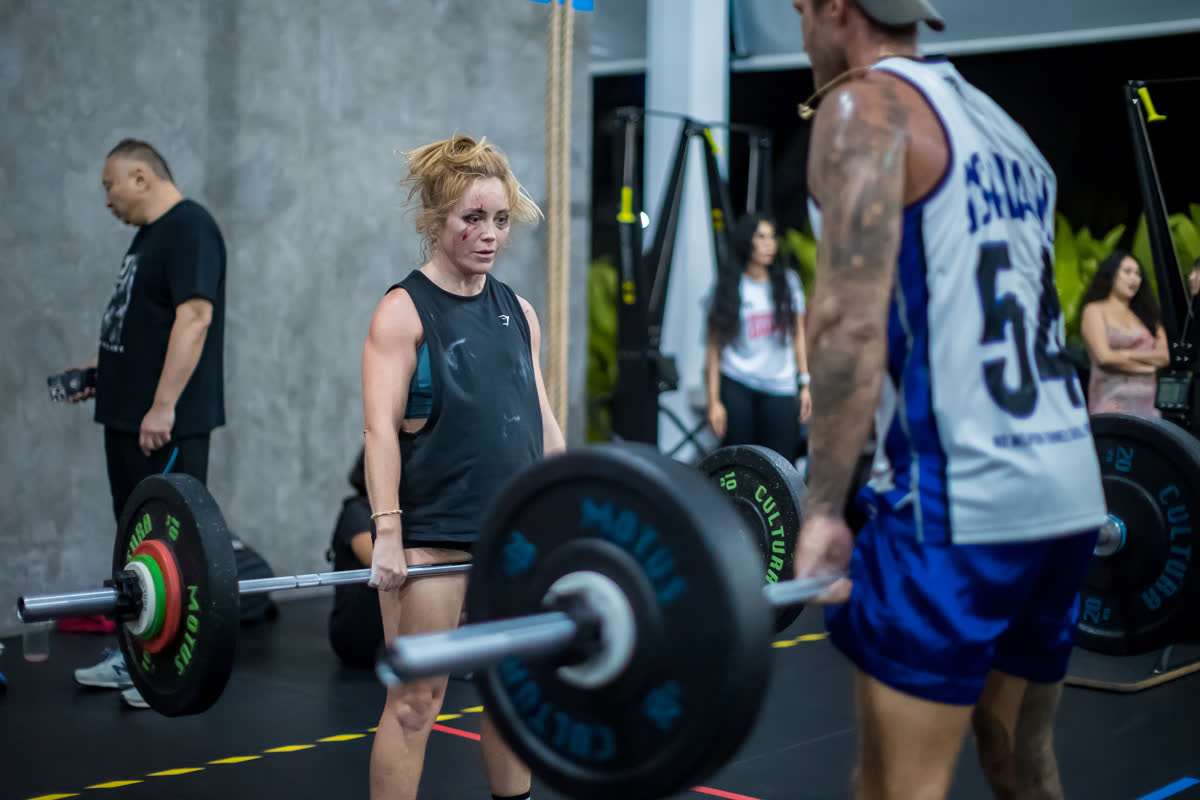 Athlete with a loaded barbell, judge watching