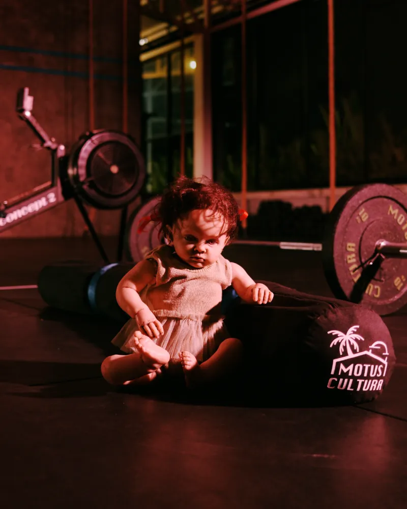 Doll sitting by a barbell and a rower, Workout 1 art